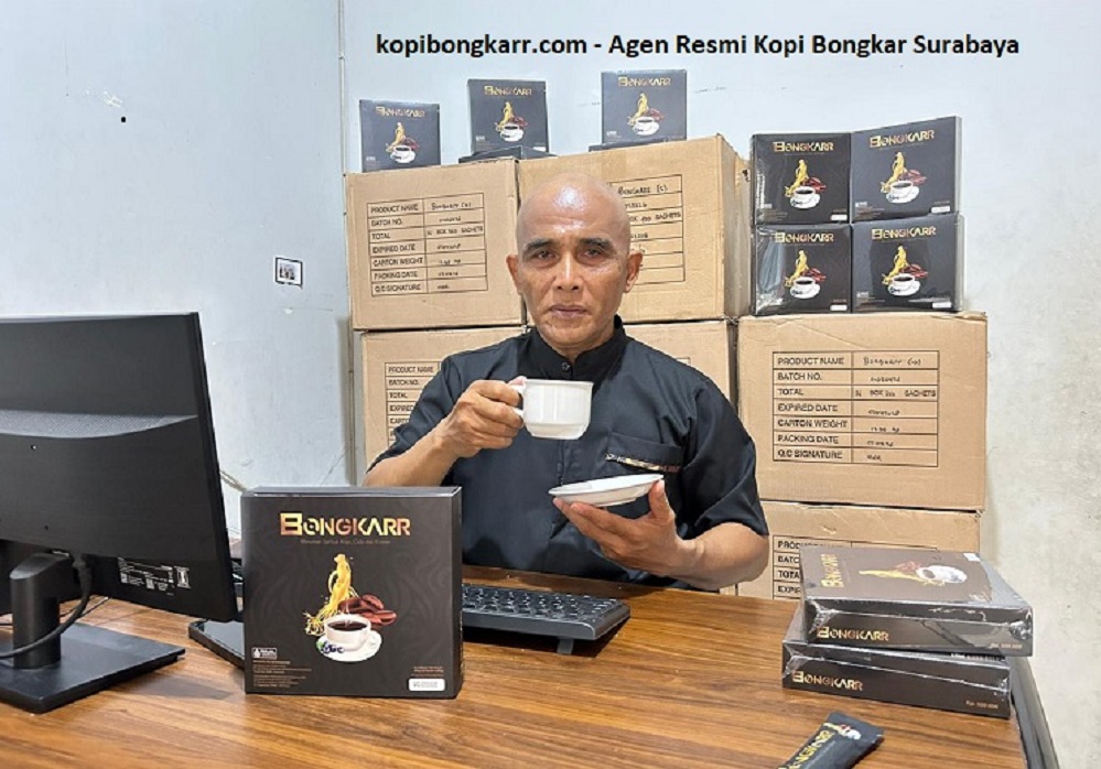 Penulis artikel Agen Resmi Kopi Bongkar Surabaya sedang mengkonsumsi secangkir kopi stamina di meja kerja, dengan latar belakang ketersediaan puluhan karton stok Kopi Bongkar asli yang siap dikirim ke Surabaya dan seluruh Indonesia.