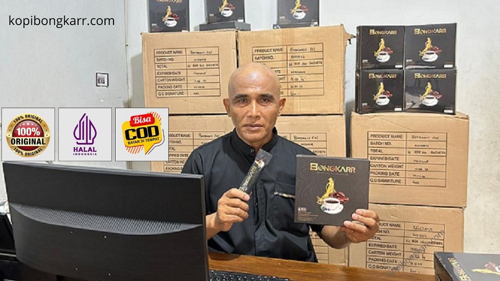 Agen resmi Kopi Bongkar Semarang sedang memegang box dan saset produk asli BPOM dengan latar belakang stok karton siap kirim COD.